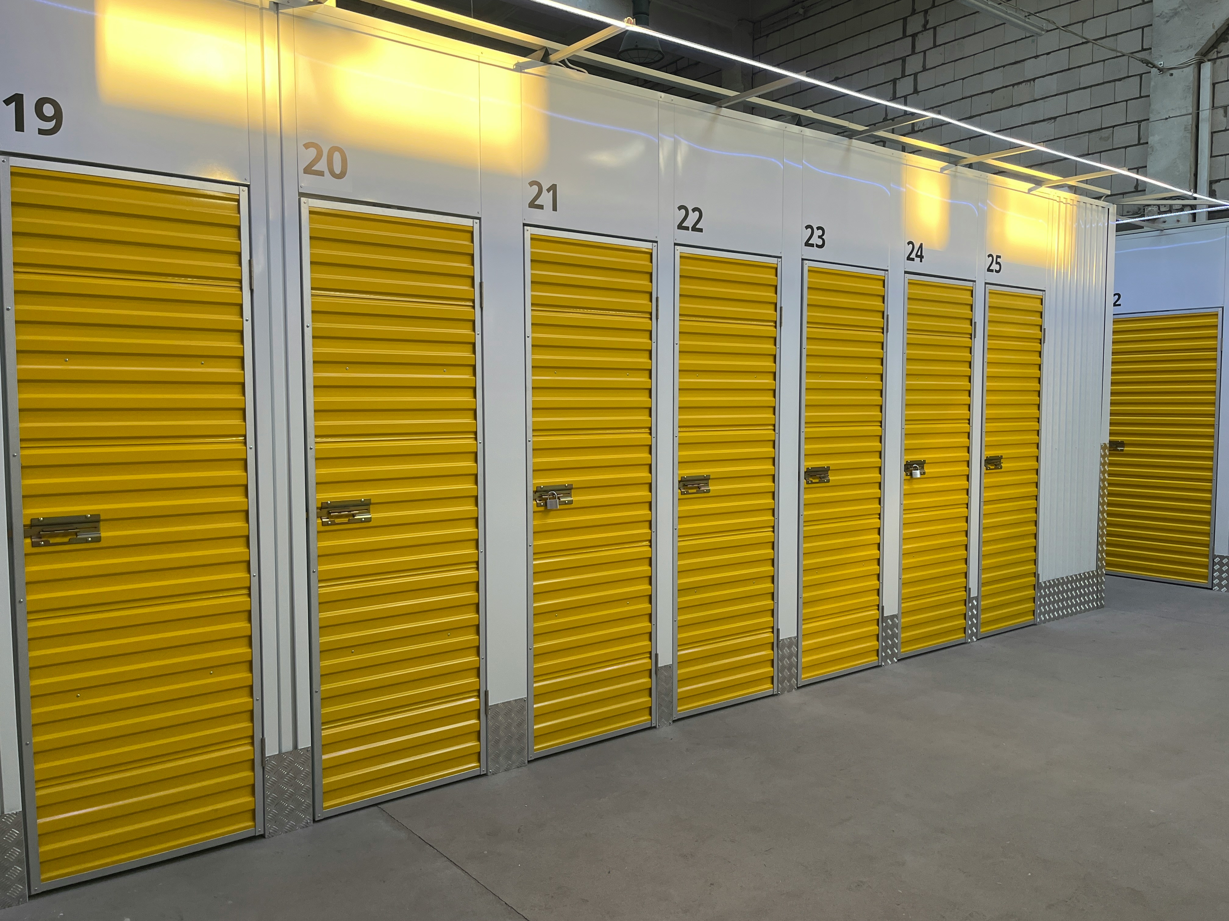 Yellow numbered self-storage doors in modern facility